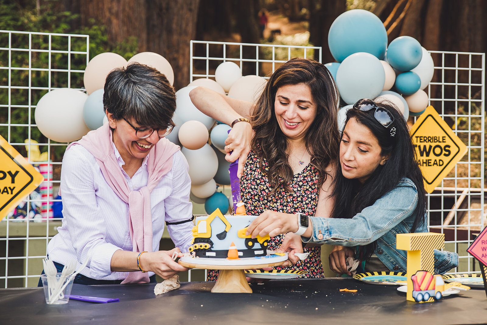 Milestone first birthday event with mother and family cutting the birthday boys cake
