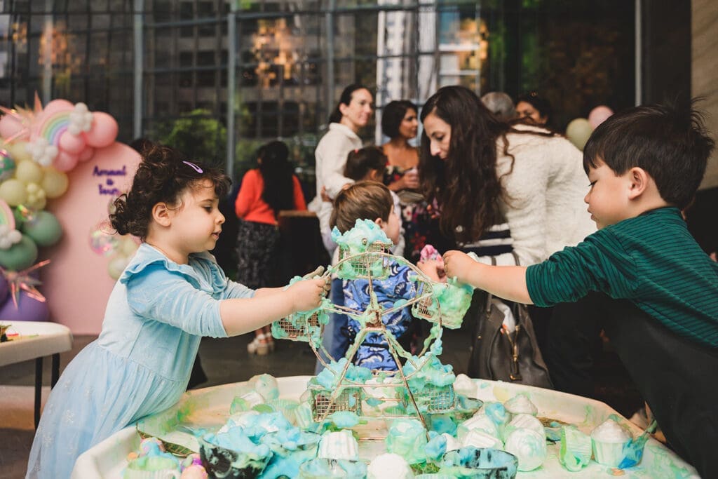 Photo of kids at a birthday party playing with foam and ferris wheel around a sensory play table designed and organized by Oogubi events and photographed by Mini Anna Photography