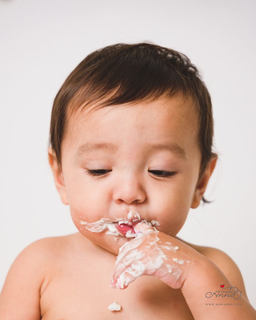 Messy cake smash moment with frosting everywhere