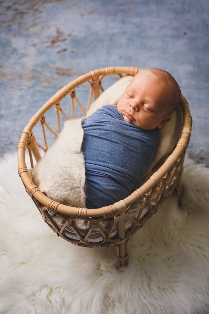 Sleeping baby in basket for newborn photoshoot