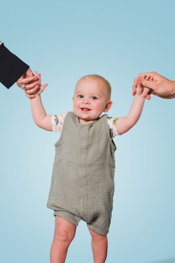 Parents holding baby's hand for first birthday photos