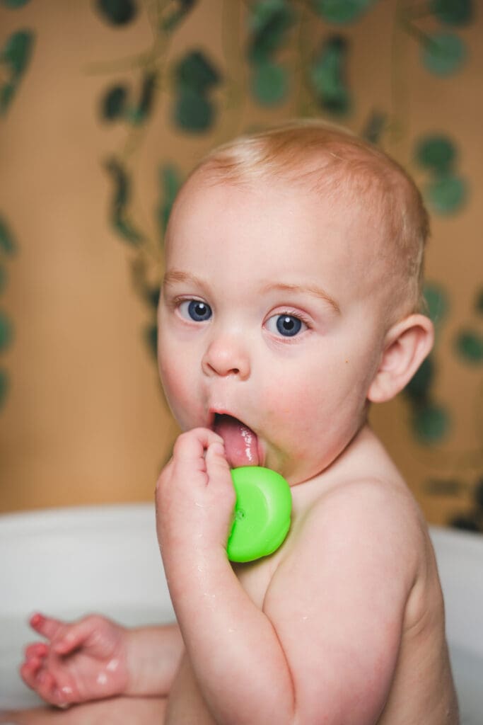 Toddler splashing in milk bath photoshoot