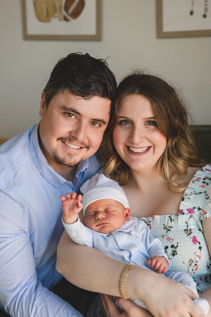 New Mom and Dad holding their sleepy newborn during their celebration for baby's arrival at home.