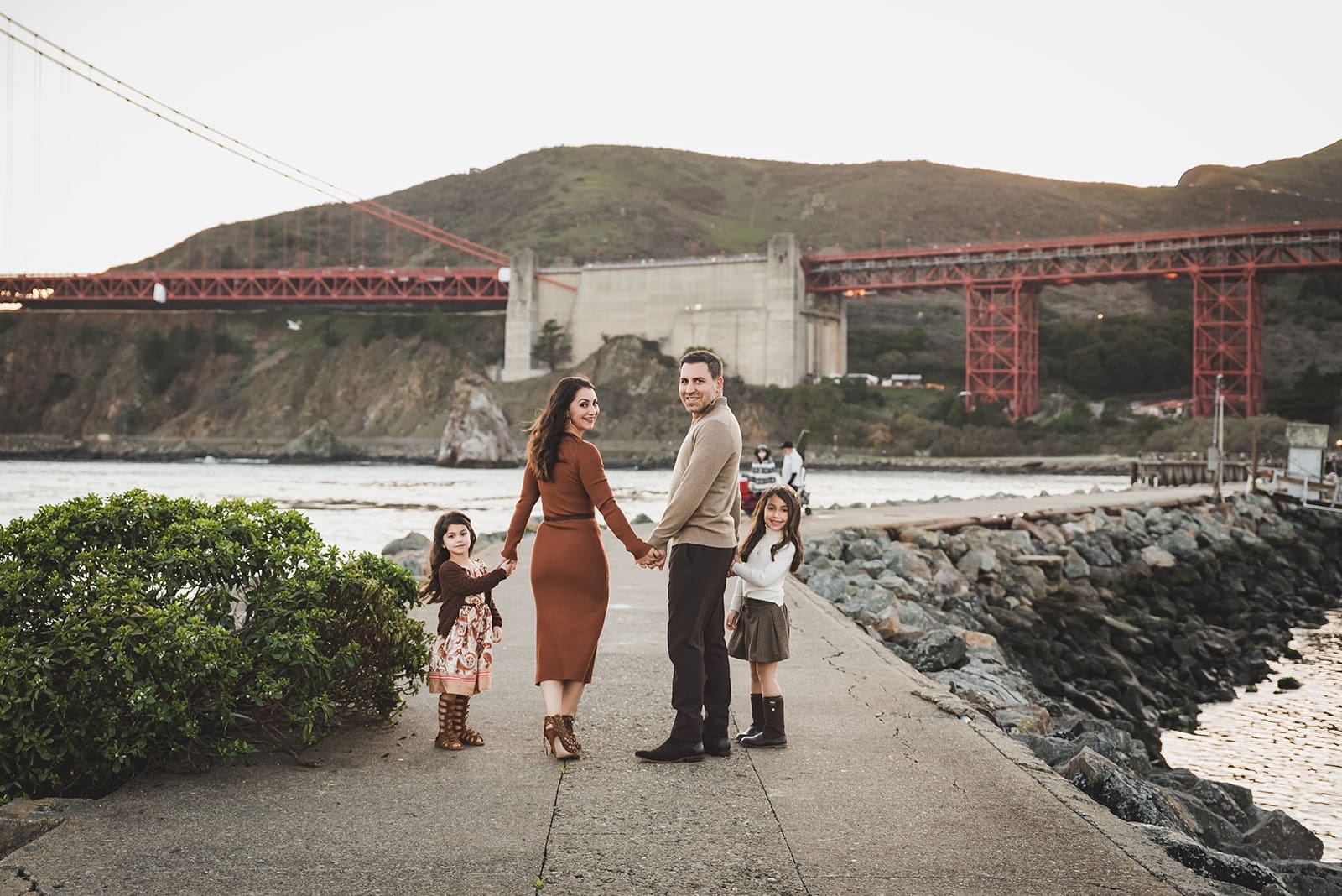 Family photo session at Cavallo Point in Sausalito with Golden Gate Bridge views and kids playing on open grassy fields