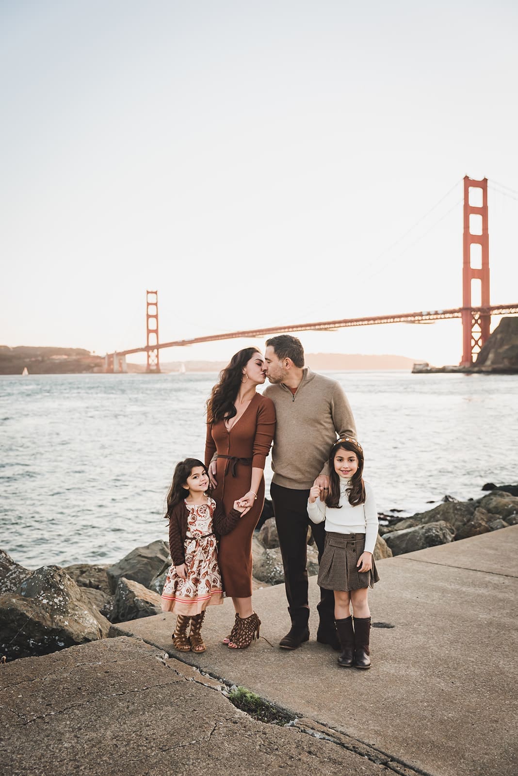 Family photo session at Cavallo Point in Sausalito with Golden Gate Bridge views and kids playing on open grassy fields
