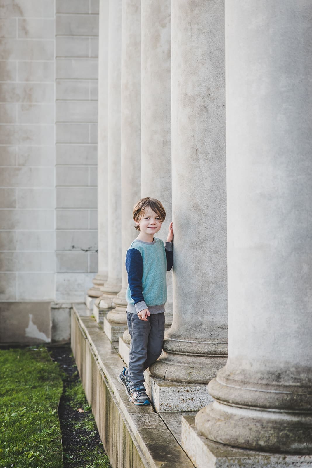 Family photo session at Legion of Honor in San Francisco, with iconic columns, trees and lush greenery. 