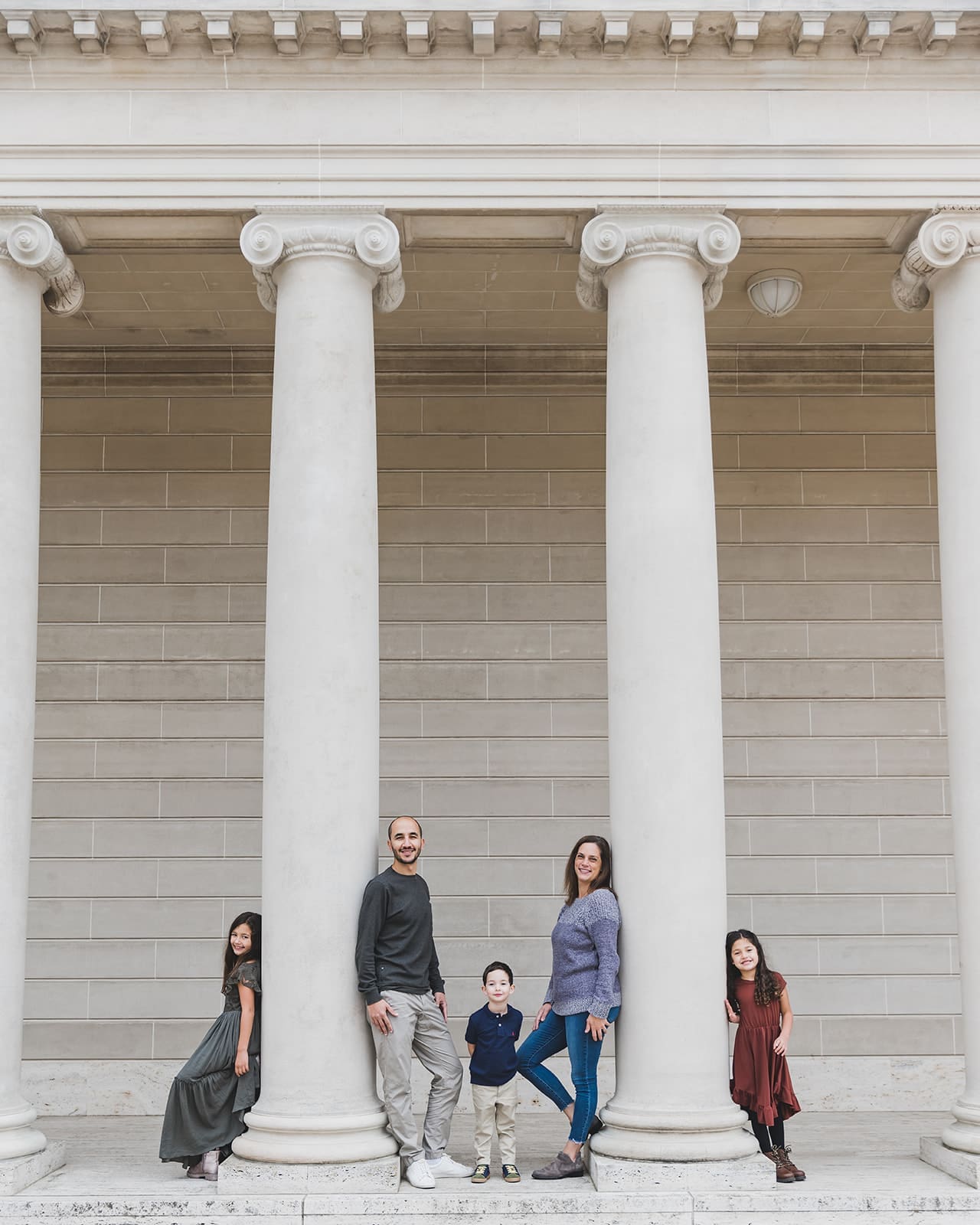 Family photo session at Legion of Honor in San Francisco, with iconic columns, trees and lush greenery. 
