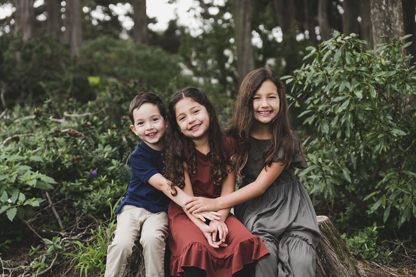 Family photo session at Legion of Honor in San Francisco, with iconic columns, trees and lush greenery. 