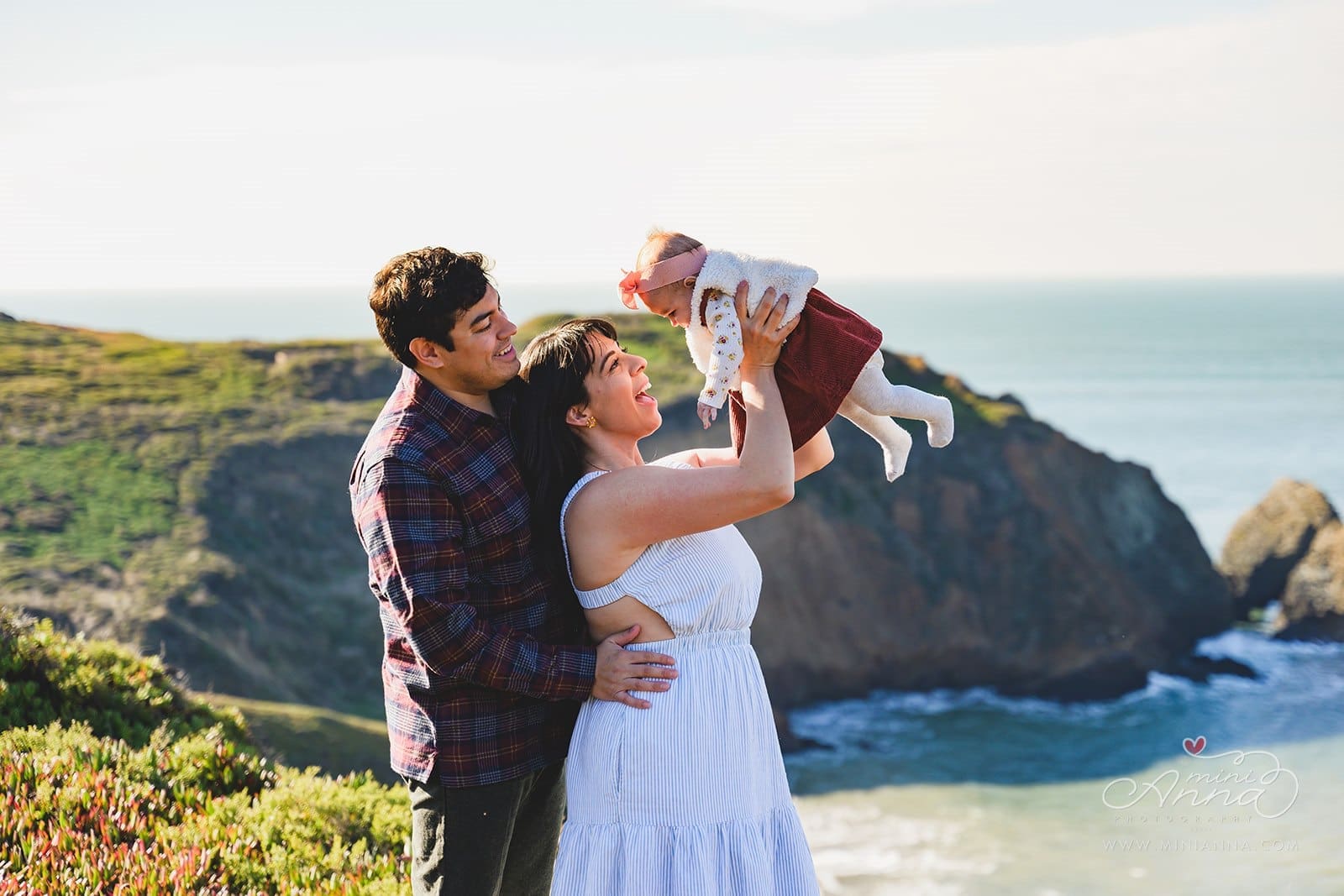 Candid family photos at Marin Headlands with coastal cliffs, golden sunset light, and wind-swept movement