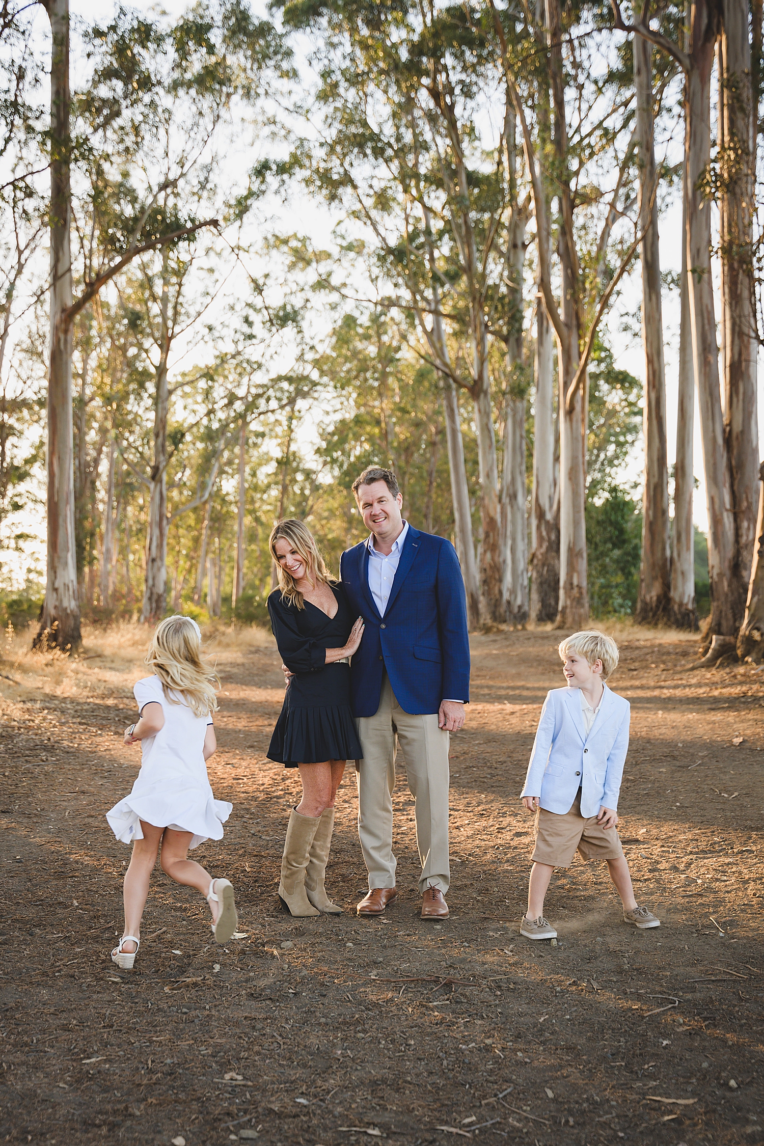parents in blue outfits watch their kids run around showing what to wear for family photos