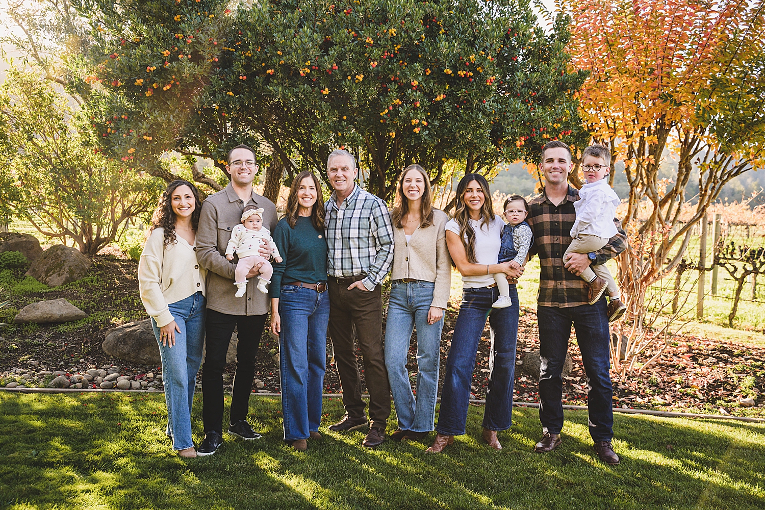 extended family stands together under fall trees by San Francisco photographer
