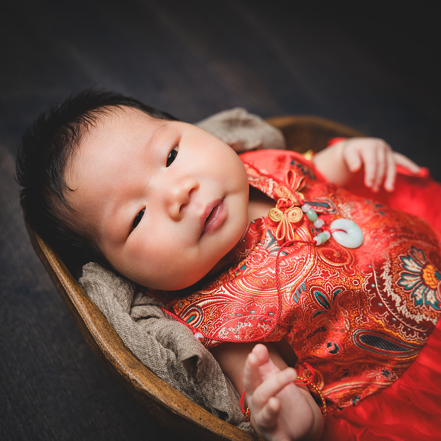 infant in red outfit in basket by San Francisco family photographer